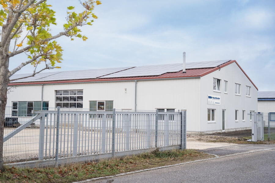 Blick von außen auf die Produktionshalle von Neuhäusler Zerspanungstechnik in Buch bei Illertissen mit PV-Anlage für nachhaltige Produktion.