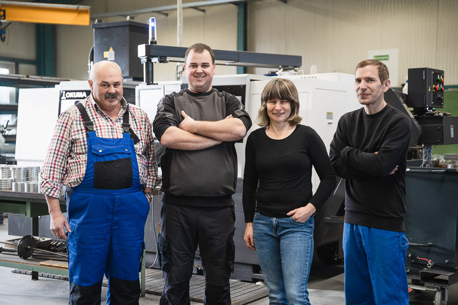 Team in der Produktionshalle von Neuhäusler Zerspanungstechnik bei der Fertigung von Präzisionsteilen. 